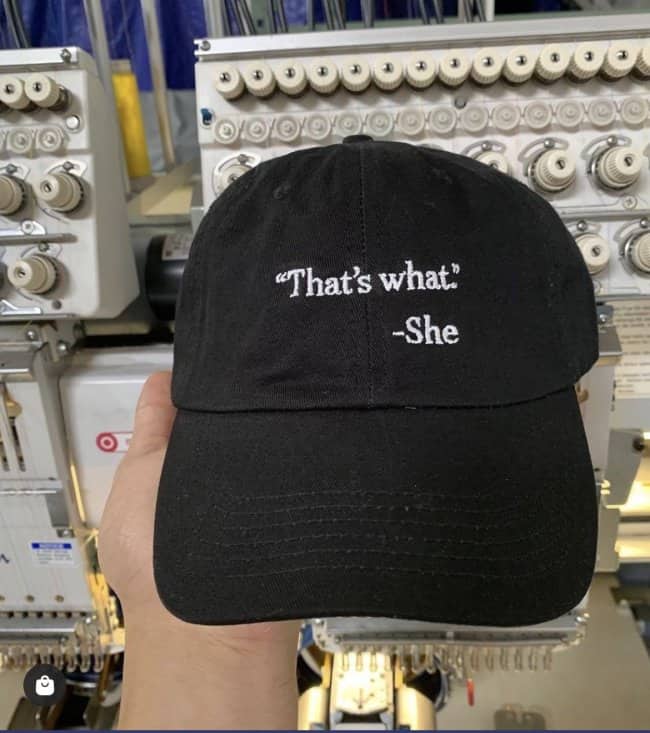 Black baseball hat embroidered in white font with a minimalist quote reading That's what. -She.