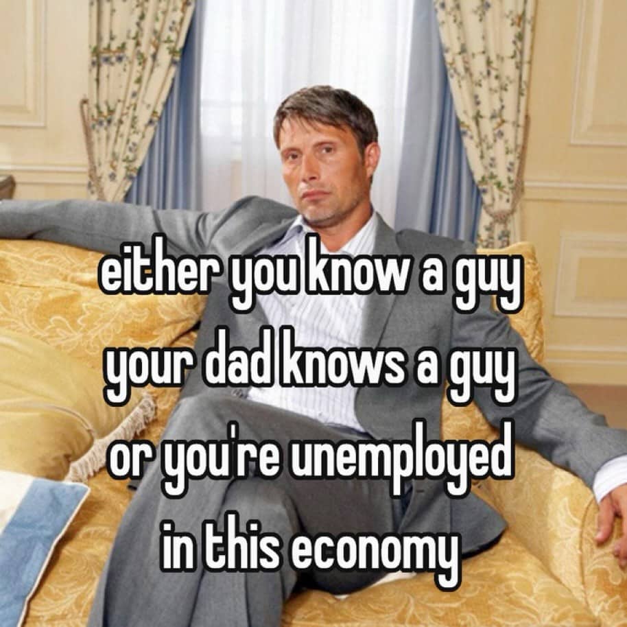 Mads Mikkelsen sitting relaxed on a couch beneath funny memes text about the economy.