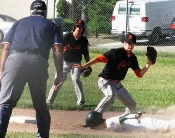 Funny baseball optical illusion photo where a player appears to headbutt the runner.