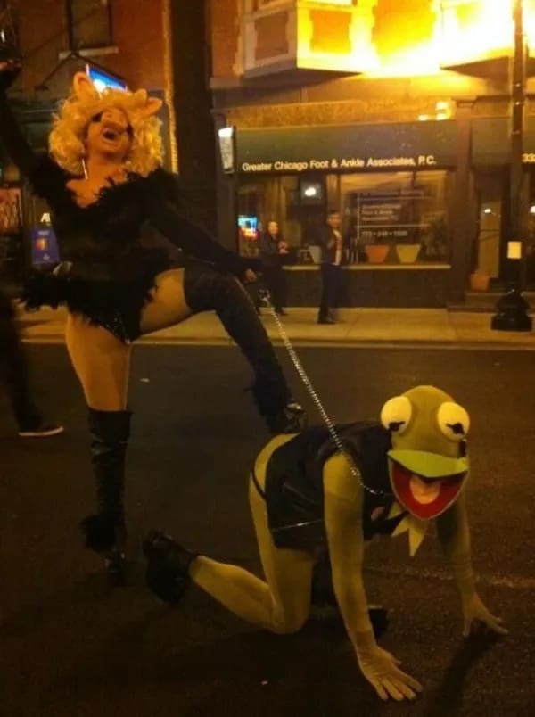 Funny memes Miss Piggy and Kermit the Frog cosplay with leash in street costume setup.