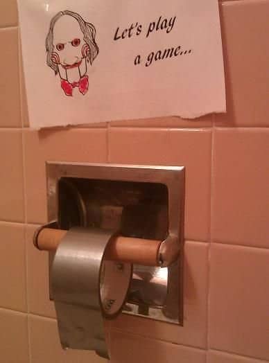 Roll of duct tape in toilet paper holder with Jigsaw note funny pranks.
