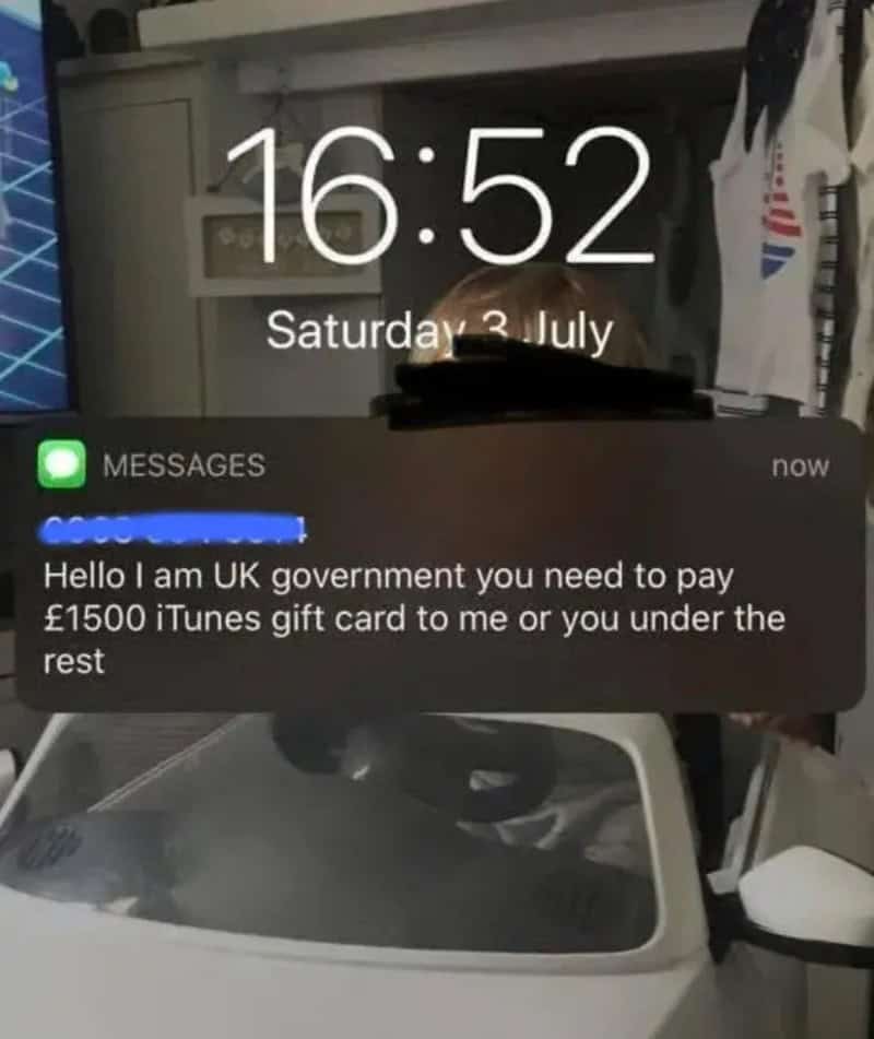 Lock screen notification showing a ridiculous scam text claiming to be the UK government demanding iTunes cards.