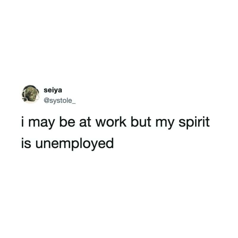 Minimalist text tweet stating 'i may be at work but my spirit is unemployed' in a funny work meme.