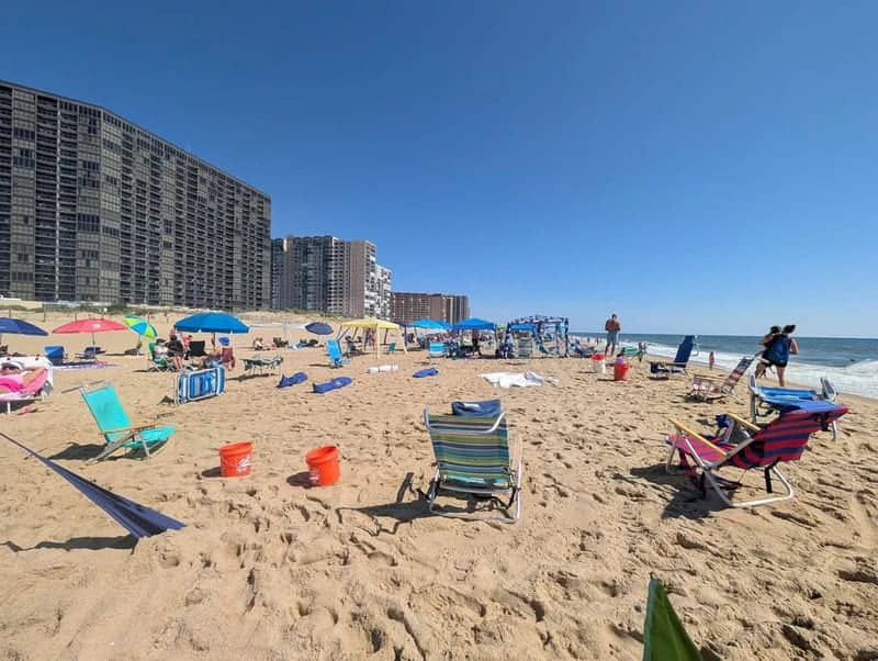 Crowded beach displaying main character syndrome with one massive canopy hoarding prime sand real estate.