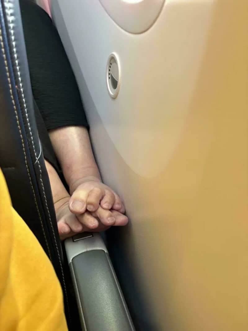 Bare feet invading an airplane seat space perfectly illustrating main character syndrome in public transport.