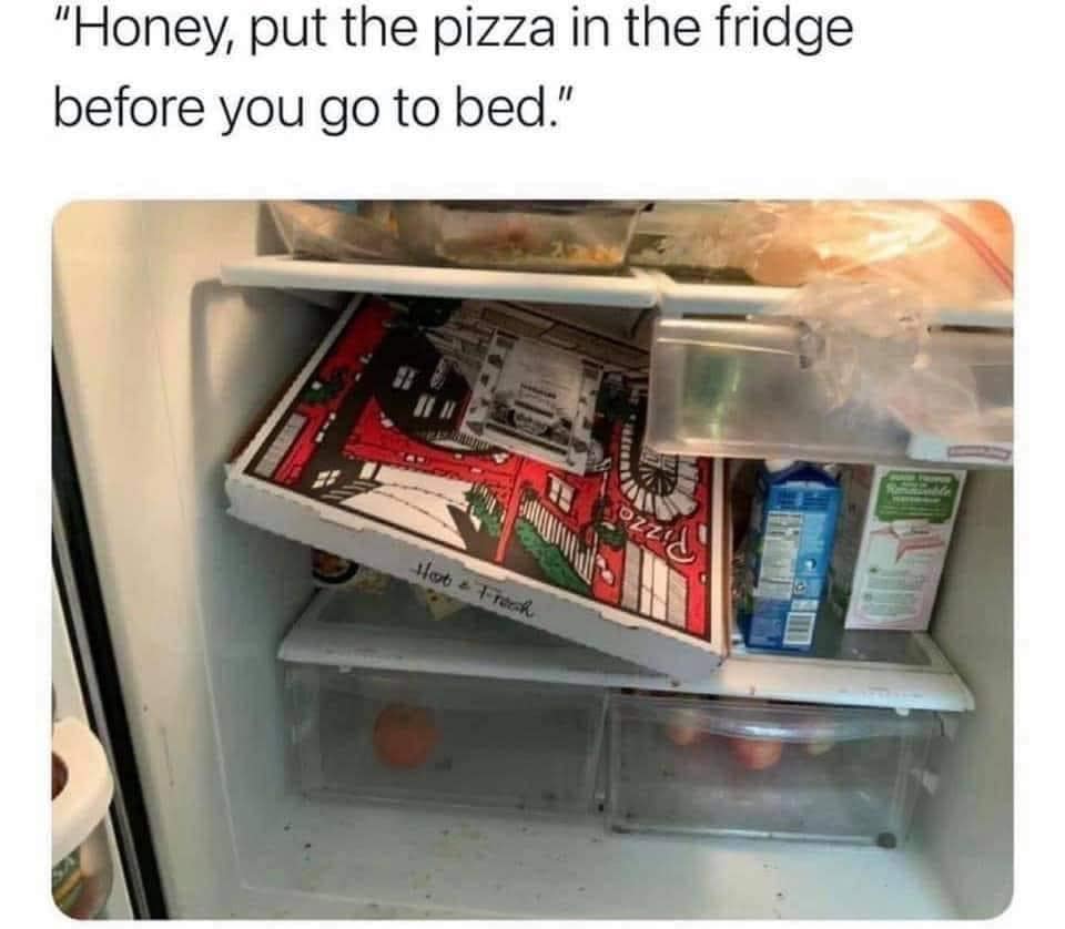 A meme dump photo of a full-sized cardboard pizza box awkwardly jammed diagonally inside a packed refrigerator.