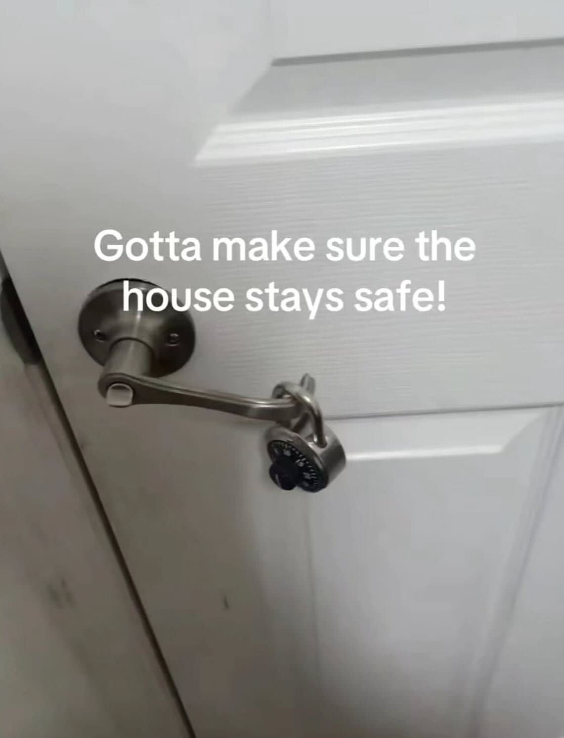 Interior door lever handle uselessly locked with a combination padlock claiming to keep the house safe in a meme dump.