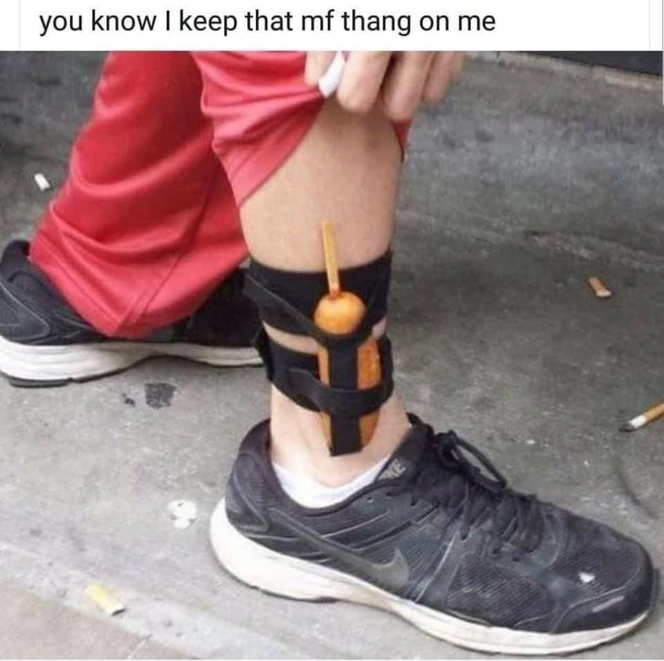 Person concealing a hot corn dog on a stick inside an ankle holster strap in a meme dump.