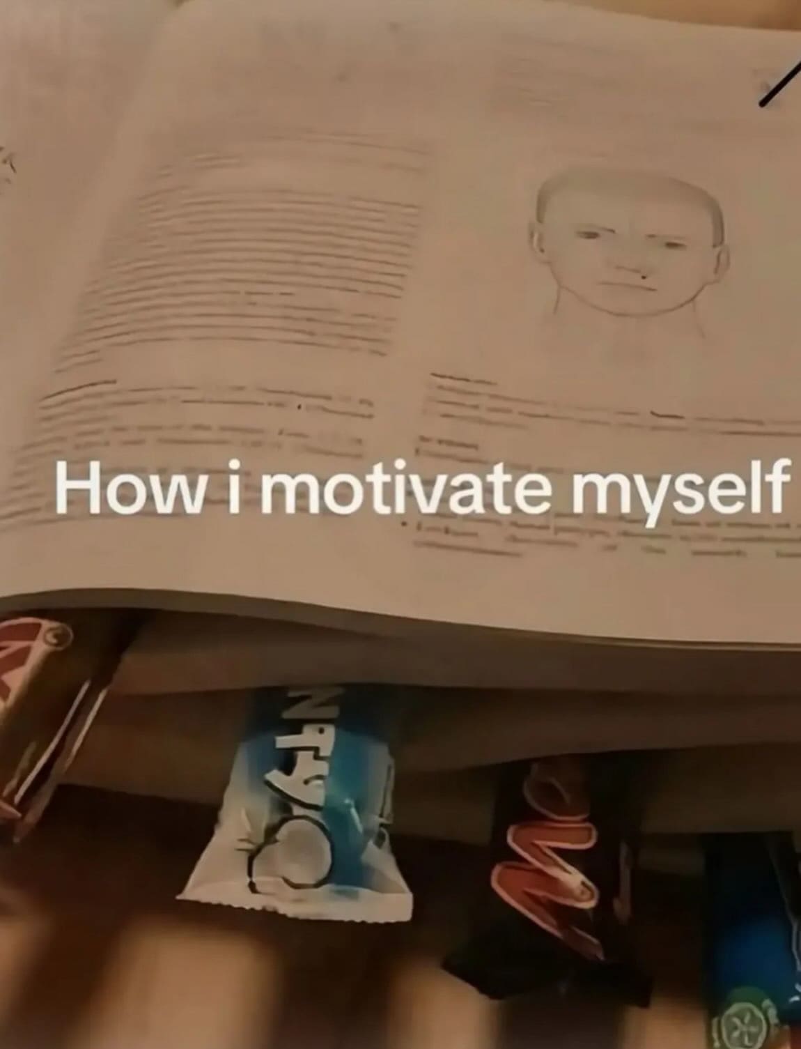 Open study textbook hiding chocolate candy bars underneath the pages labeled as a self-motivation hack in a meme dump.