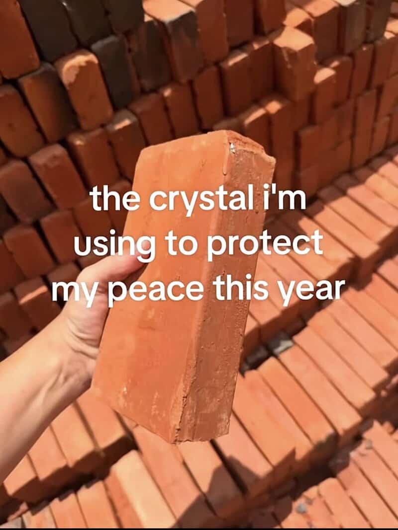 Hand holding a solid red construction brick labeled as a peace-protecting crystal in a meme dump.