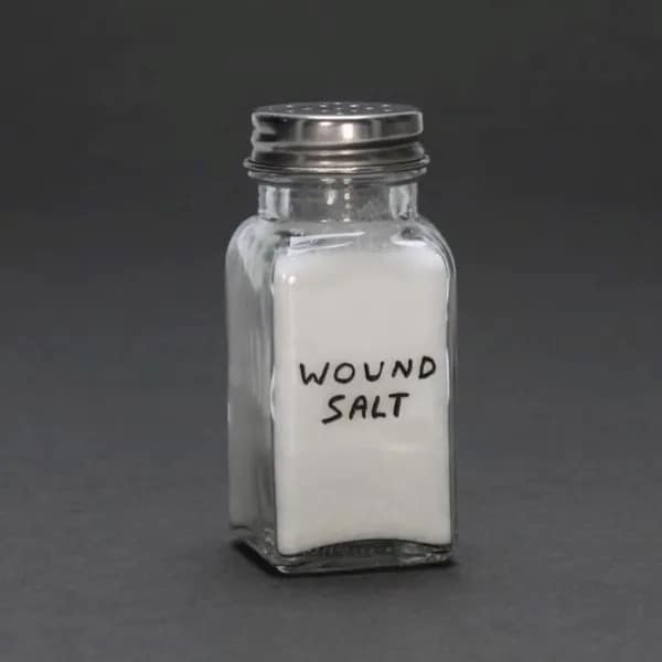 Glass diner salt shaker filled with white salt and hand-labeled 'WOUND SALT' in permanent marker, shared in a funny meme.