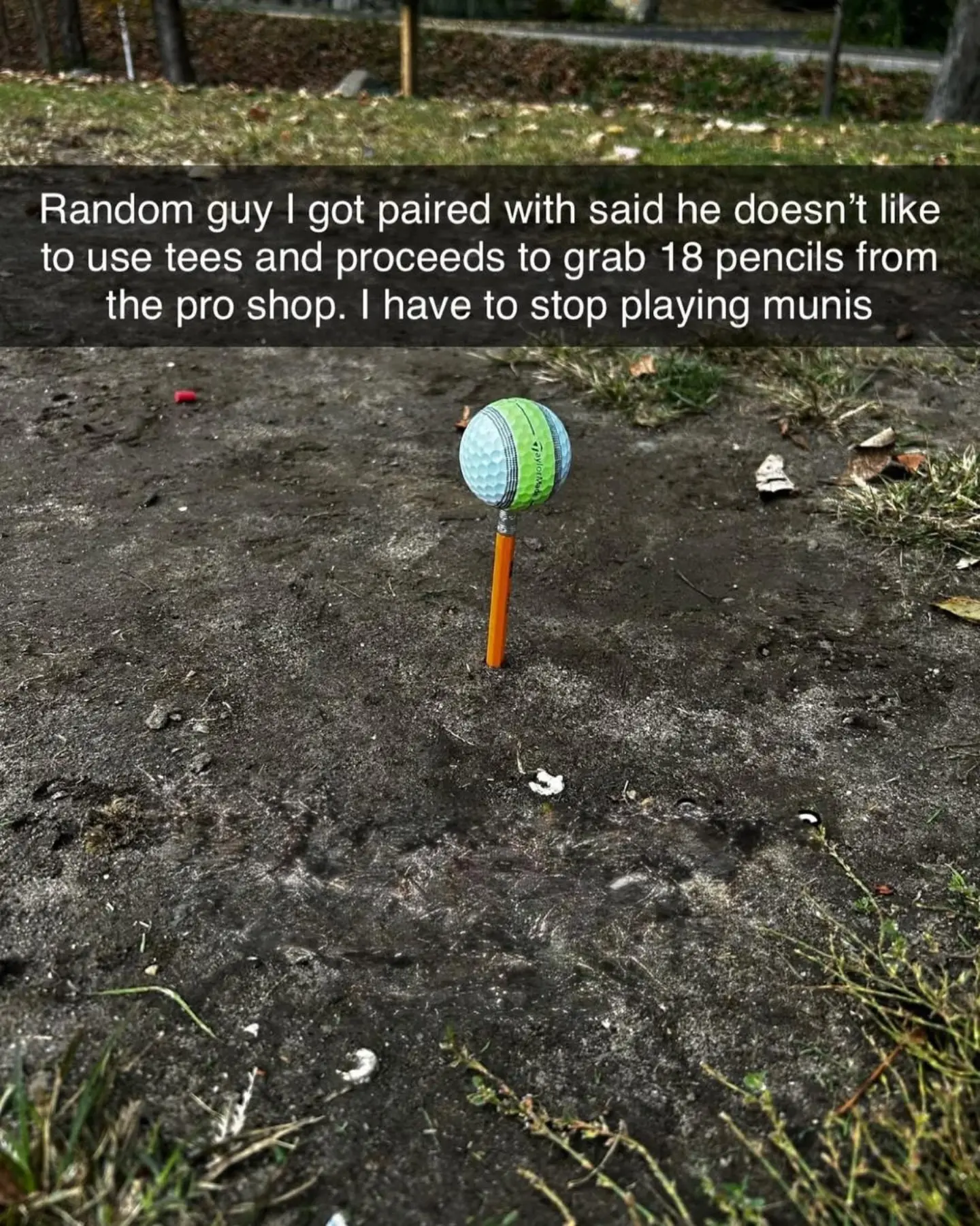 Golf ball balanced on a wooden score pencil pushed straight into the dirt on a municipal course in a meme dump.
