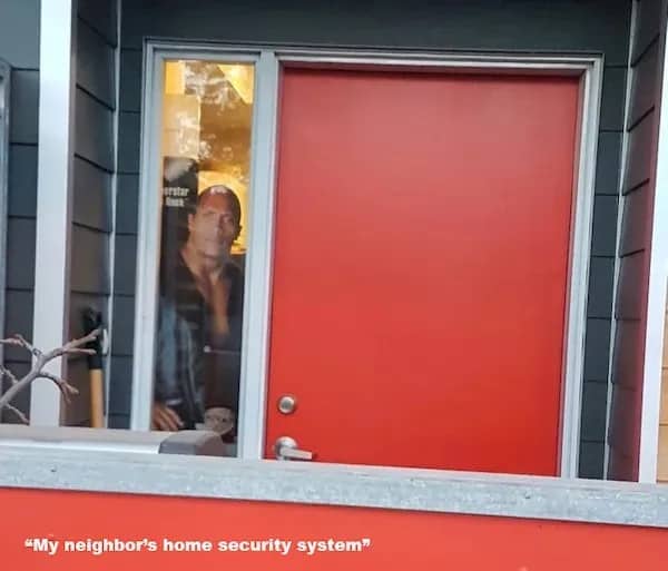 Lifesize cutout of Dwayne The Rock Johnson visible through front door glass as security.