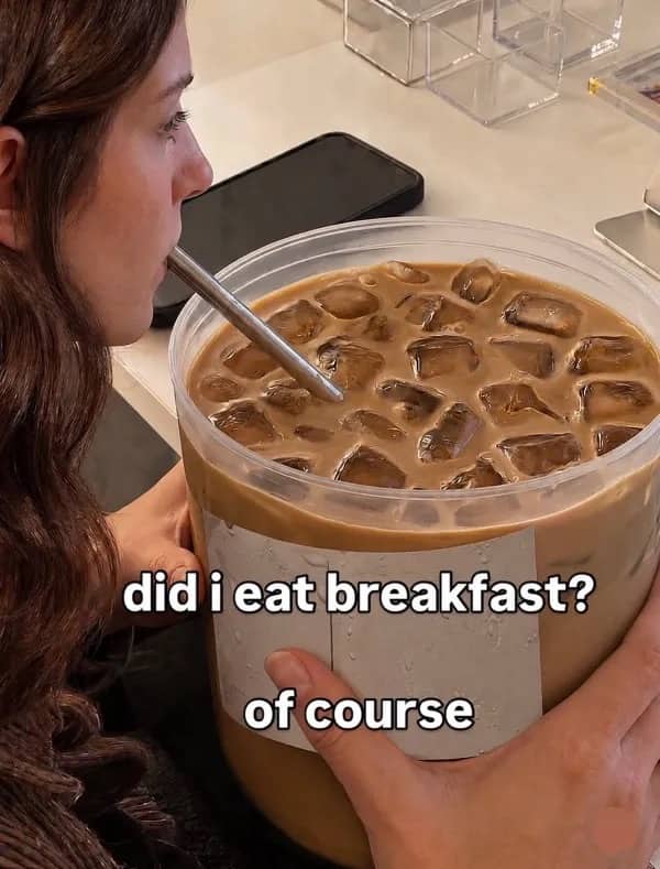 Person drinking massive tub of iced coffee with breakfast joke text funny meme.
