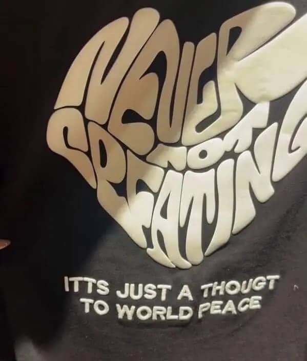 Black hoodie with heart shaped text reading never not screaming about world peace graphic.