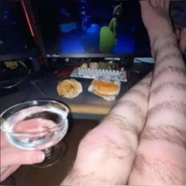 Hairy legs shaved into tiger stripes, propped beside fast food and a drink.