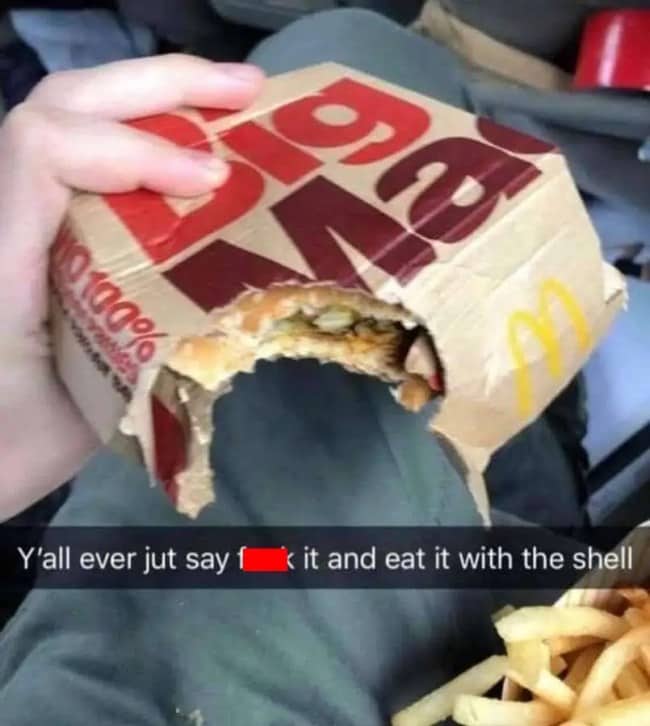 Half eaten Big Mac still inside its cardboard box, captioned about eating the shell.