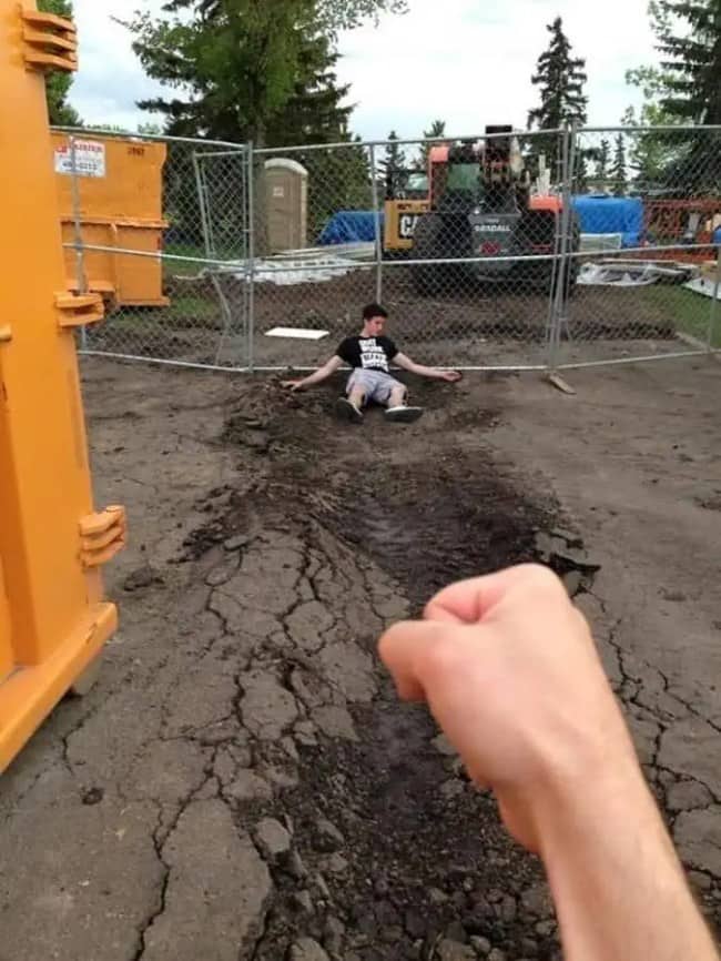 First person fist aimed at a guy sprawled in fresh dirt like a knockout blow.