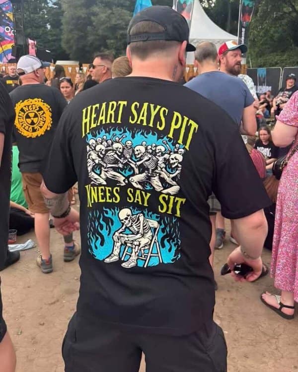 Concert shirt reading heart says pit, knees say sit, with dancing skeletons.