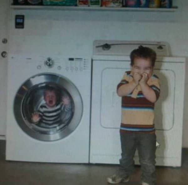 Young boy laughing maniacally while a baby cries inside a washing machine.