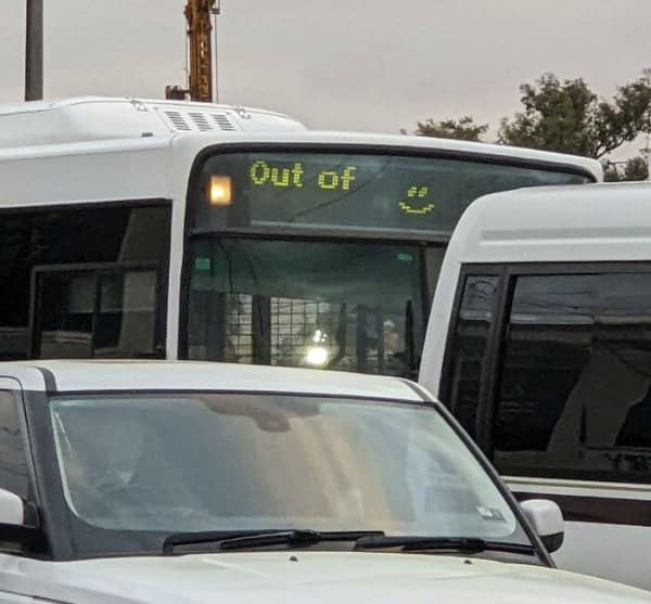 Bus destination display reading out of, followed by a smiley face.