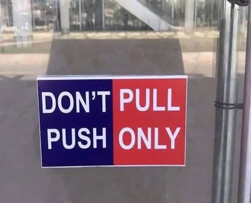 Confusing door sign with split colors that reads both don't pull and push only simultaneously.