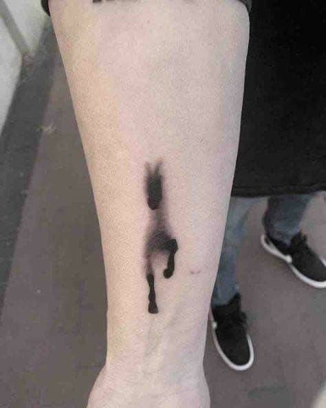 Dynamic motion blur running horse unique tattoo inked on arm creating a fast action illusion.