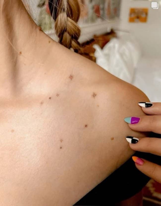 Minimalist constellation unique tattoos incorporating natural skin freckles across a person's shoulder and collarbone area.